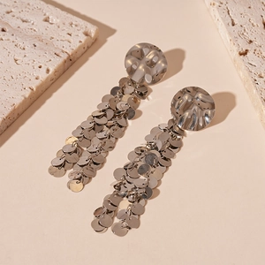Macro detail of silver sequin tassel earrings with hammered round metallic studs