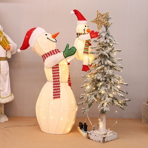 Famille de bonhommes de neige lumineux avec sapin enneigé et décoration LED chaude