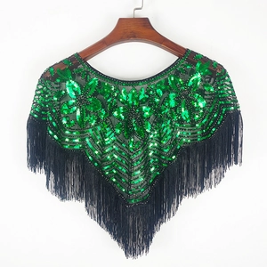 Châle en maille à paillettes vertes avec franges noires sur un cintre en bois