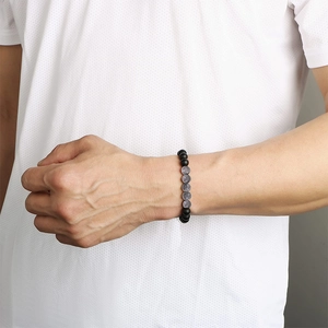 Map stone beaded bracelet for men on wrist featuring matte black and translucent grey beads