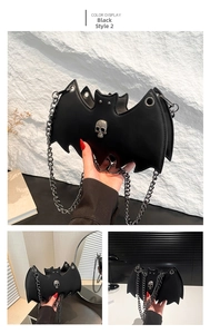 Detail view of black bat shaped bag with silver skull ornament and metal chain