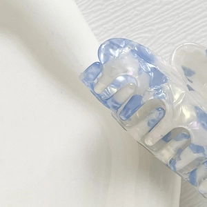 Detail einer kleinen Acetat-Haarklammer mit blauem Wolkenmuster und Perlglanz-Effekt
