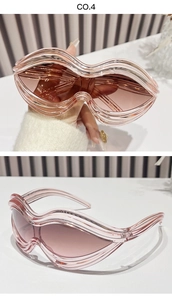Detail view of Y2K sunglasses with pink oversized wavy frames and a unique shield design