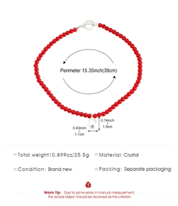 Detalle de collar de cuentas rojas con colgante de perla gota y cierre plateado