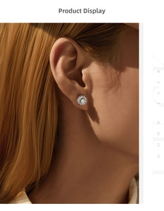 Close-up of model wearing sparkling sunflower stud earrings with green moissanite stones