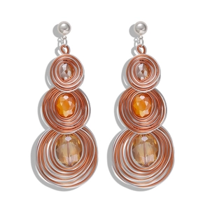 Macro detail of Bohemian wire-wrapped heart earrings with amber gemstone inlays