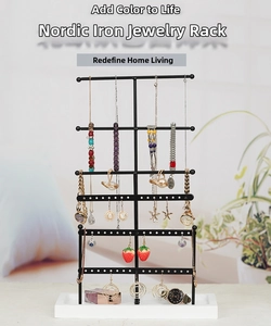 Detailed close-up of a 6-tier black metal jewelry organizer with white base in home setting