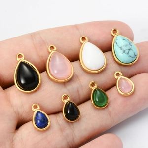 Handheld view of assorted colorful teardrop stone pendants with gold-plated stainless steel edges
