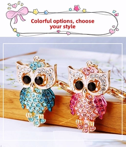 Detail of owl keychains featuring blue and pink crystal rhinestones on gold metal finish