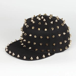 Detailed side view of black snapback hat featuring gold conical metal spikes and rivets