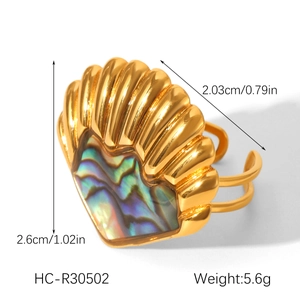Macro shot of shell shaped gold ring with abalone inlay and adjustable open band design