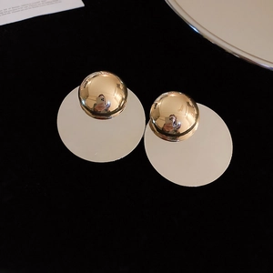 Detailed view of golden geometric stud earrings with polished mirror finish on black velvet
