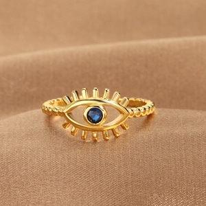 Gold-plated Evil Eye open ring with blue stone on luxury brown satin background