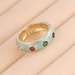 Detailed macro view of gold-plated enamel ring with multi-colored gemstone inlays