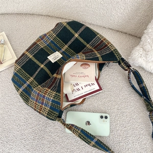 Detail shot of the spacious vintage plaid crossbody bag with books inside for storage view