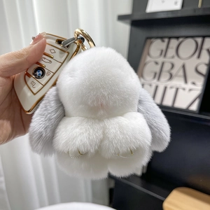 Close-up of white plush bunny keychain with gray ears attached to a car key fob