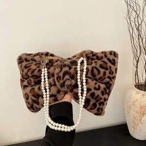 Detail of leopard print faux fur handbag with pearl straps and decorative bow