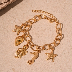Detailed view of ocean theme gold bracelet with starfish, seahorse and octopus charms