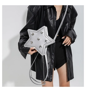 Silver star crossbody bag with 3D butterfly, studs, and chain strap on a black outfit