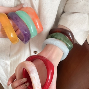 Macro detail of thick resin bangles showing marbled texture and vibrant colors