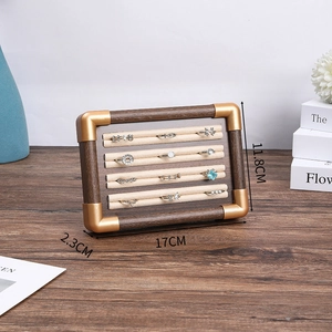 Macro view of walnut jewelry tray with beige velvet ring slots and dimensions 17x11.8x2.3cm