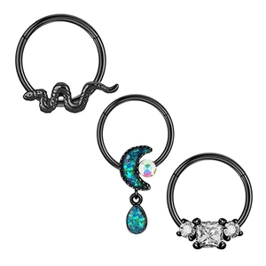 Detailed view of three black nose rings featuring snake, moon and square zircon designs