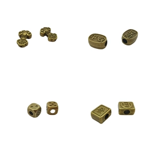 Close-up of bronze metal beads with traditional Chinese lucky symbols for DIY jewelry