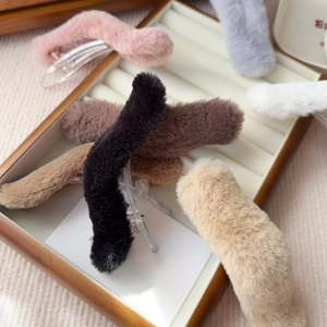 Close-up of soft faux fur hair clips in various colors displayed in a wooden jewelry tray