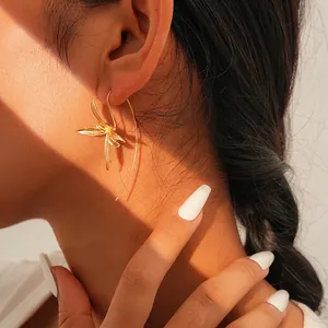Elegant gold iris flower hook earring shown on model with aesthetic light and shadow