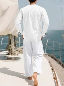 Rückansicht eines Mannes in weißem Leinenhemd und weiter Hose auf einem Schiffsdeck
