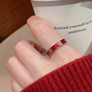 Macro detail of 18k gold plated ring with red enamel and floral zircon inlay on finger