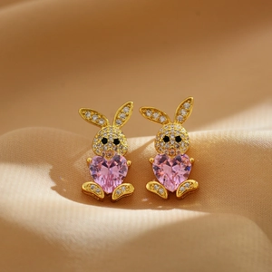 Detail of gold bunny earring featuring a large pink heart zircon and micro-pave crystals