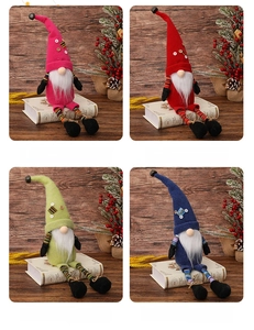 Four colorful long-leg Christmas gnomes on wooden background with festive winter decor