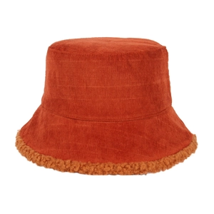 Detail of rust-red corduroy bucket hat featuring a fluffy lamb wool trim on the brim