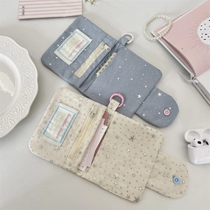Flat lay of star sequin fabric coin purses in blue and cream with zipper details