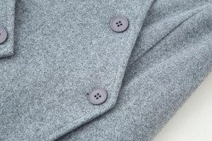 Close-up of grey wool coat texture and matching resin buttons on long outerwear