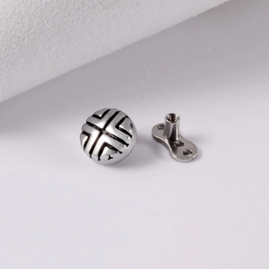 Makroaufnahme von Dermal Anchor Aufsatz aus Edelstahl mit schwarzem Kreuz und Gewindebasis