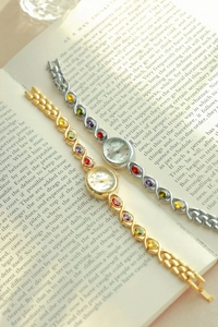 Detail of gold and silver quartz bracelet watches with multi-color gemstone inlay