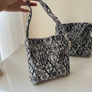 Close-up of retro embroidered canvas mini tote bag with black and white diamond pattern
