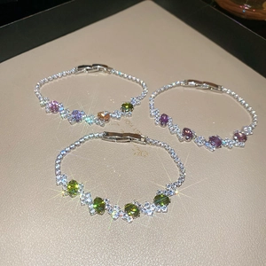Macro view of sparkly silver bracelets featuring geometric oval colored gemstones