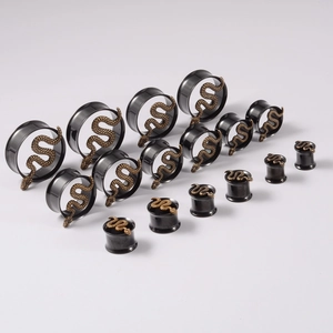 Detailed view of black ear gauges featuring vintage bronze snake relief embellishments