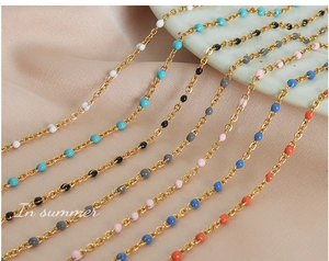 Detailed close-up of gold-plated titanium chains with colorful enamel bead accents