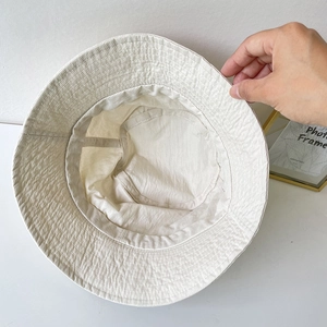 Beige nylon sun bucket hat with adjustable drawstring and breathable fabric