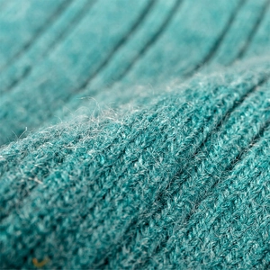 Close-up of teal rib-knit winter beanie showing thick warm wool texture and soft fabric
