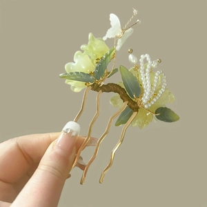 Detail view of handmade green peony hair comb with silk petals and delicate pearls
