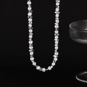 Detailed view of the irregular white pearls and silver metal beads on the necklace