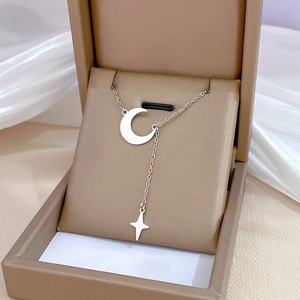 Detailed close-up of a silver moon and star pendant necklace on a jewelry display box
