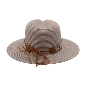 Détail macro du chapeau de soleil fedora tissé avec ruban géométrique et lacet en cuir