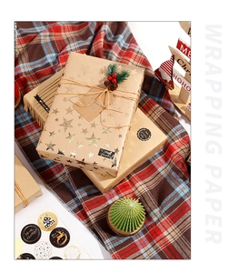Golden star pattern Christmas wrapping paper with festive stickers and hemp rope details