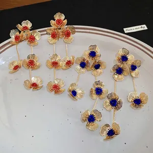 Elegant gold flower tassel earrings with red and blue crystals in a tiered floral design